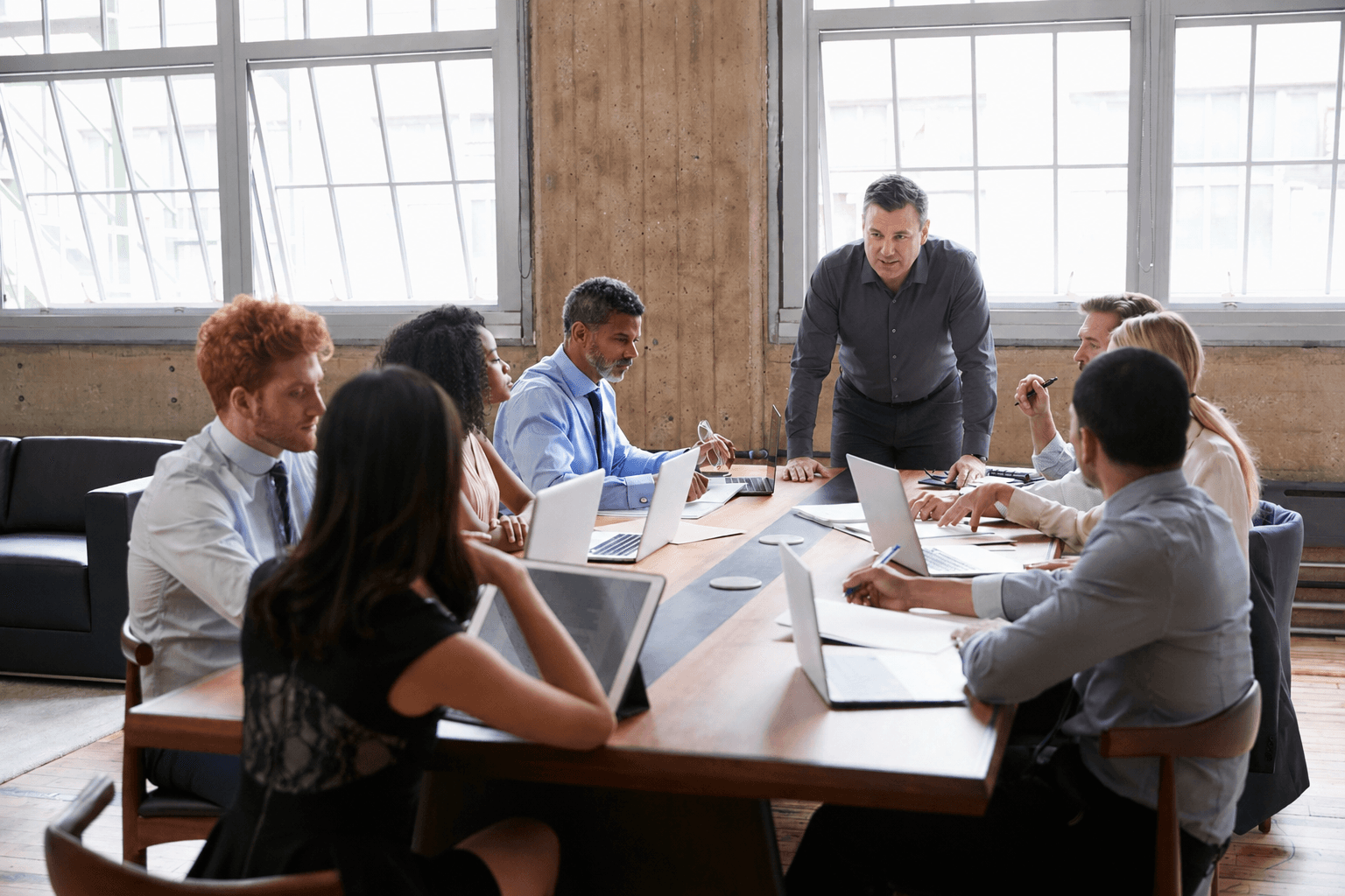 Diverse business team collaborating around a conference table in a bright, modern office setting.